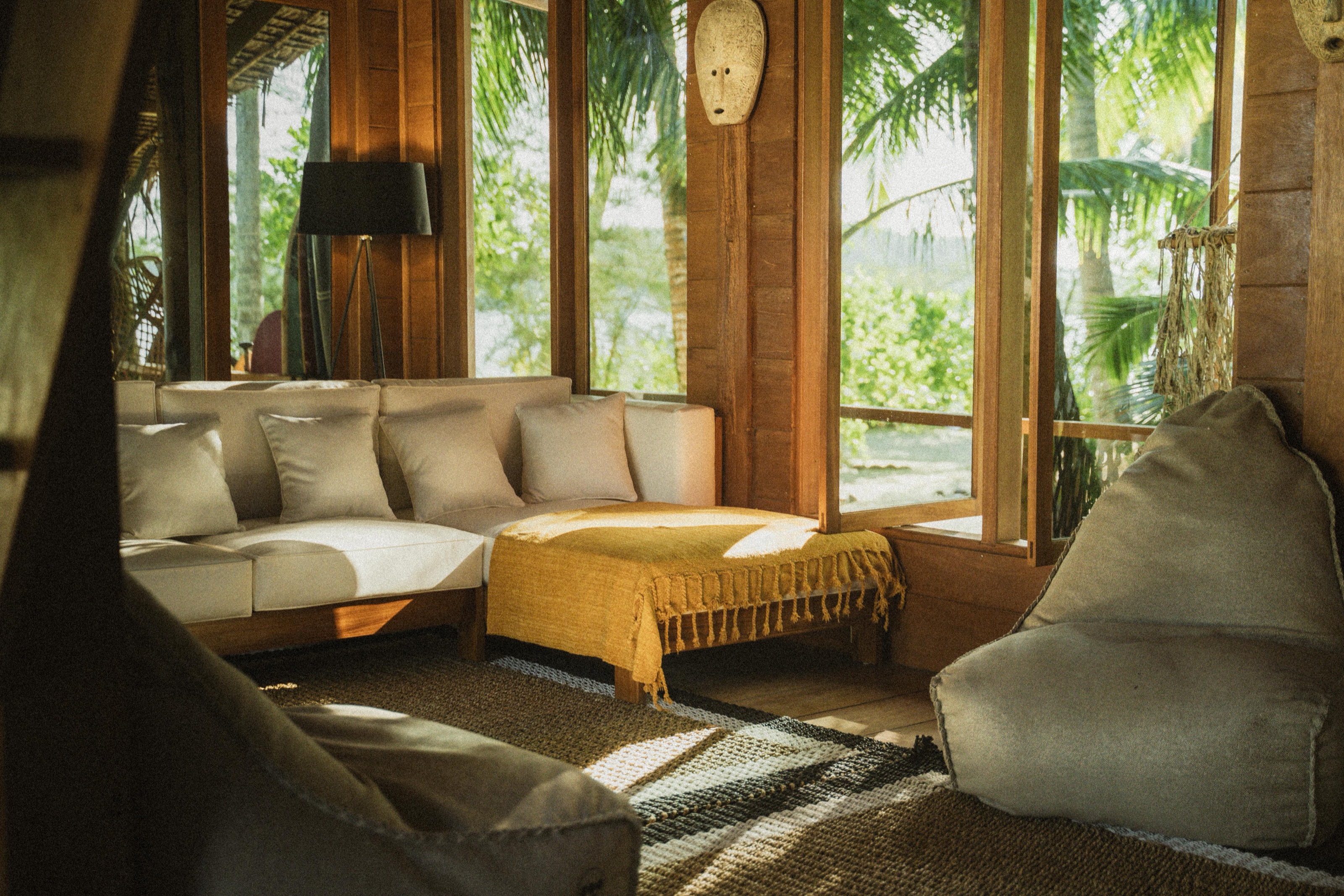 The lodge lounge on Awera Island: cushioned daybeds, timber walls and open windows to the jungle
